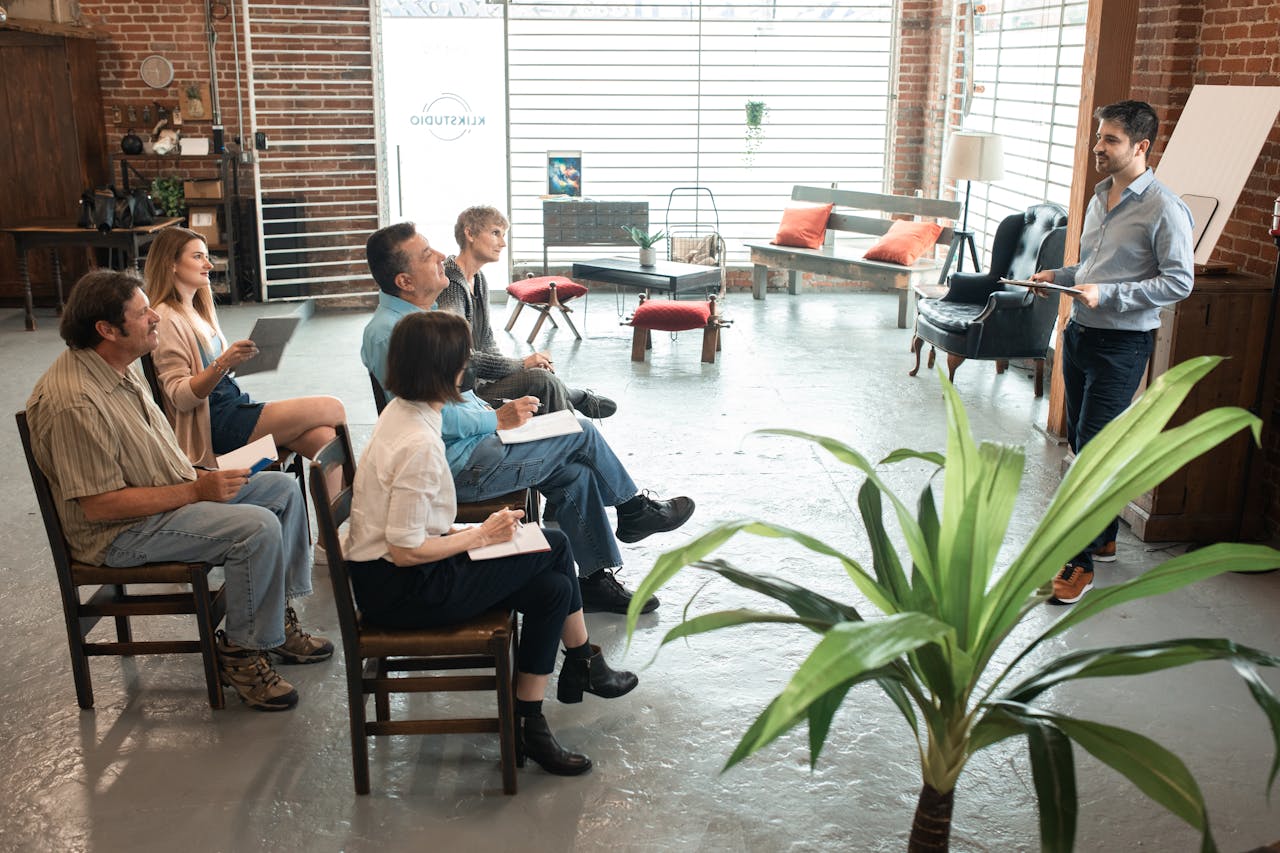 why-choose-us Diverse group of adults engaged in a workshop session inside a trendy loft.